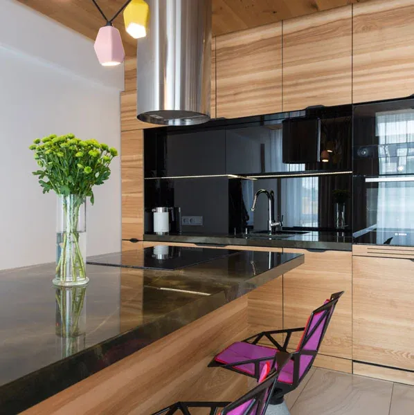 Ash veneer tall units with black glass, a black granite breakfast bar and pink chairs