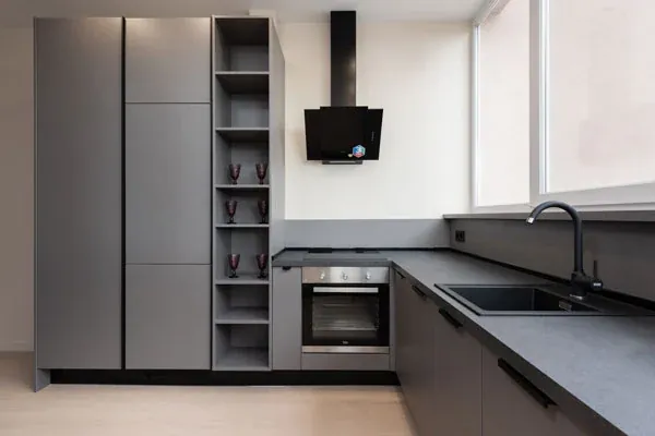 Compact graphite L-shaped kitchen with a black angled cooker hood and open shelving