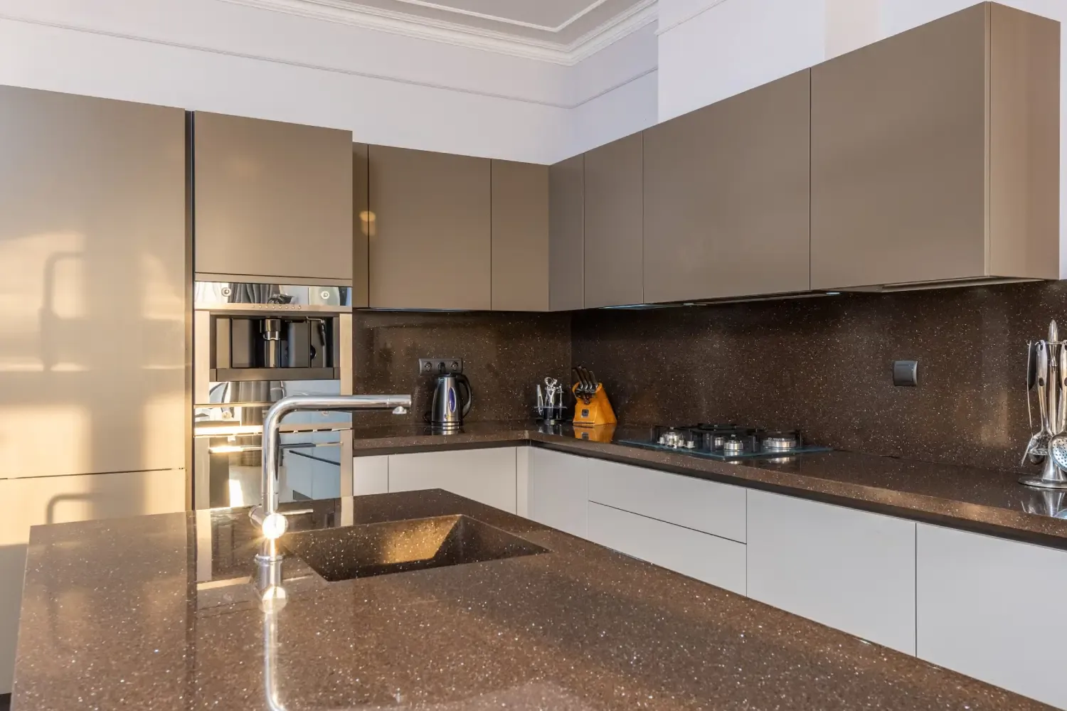 Cashmere gloss L-shaped kitchen with brown sparkle quartz worktops