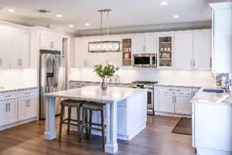 Classic white shaker kitchen with an island, pendant light and wood floor